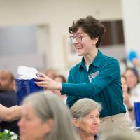committee member passing out gift at luncheon